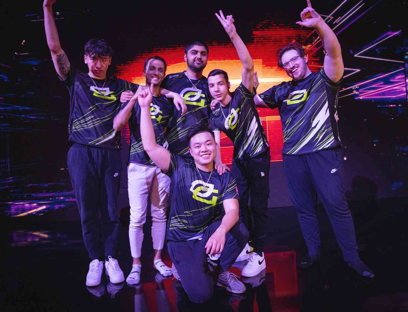 The Valorant roster for OpTic Gaming stand on stage with fists raised in a victory pose