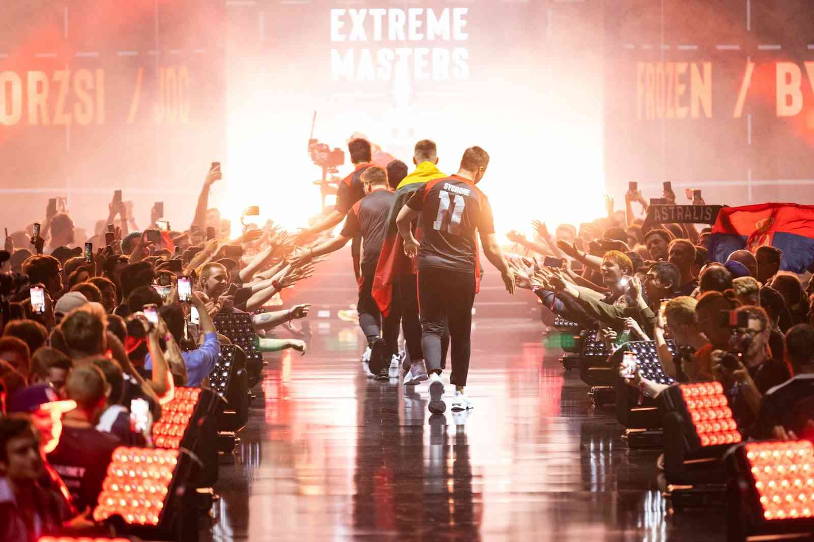 The roster for MOUZ walk on stage at IEM Cologne 2022, high-fiving fans in the crowd as they pass.